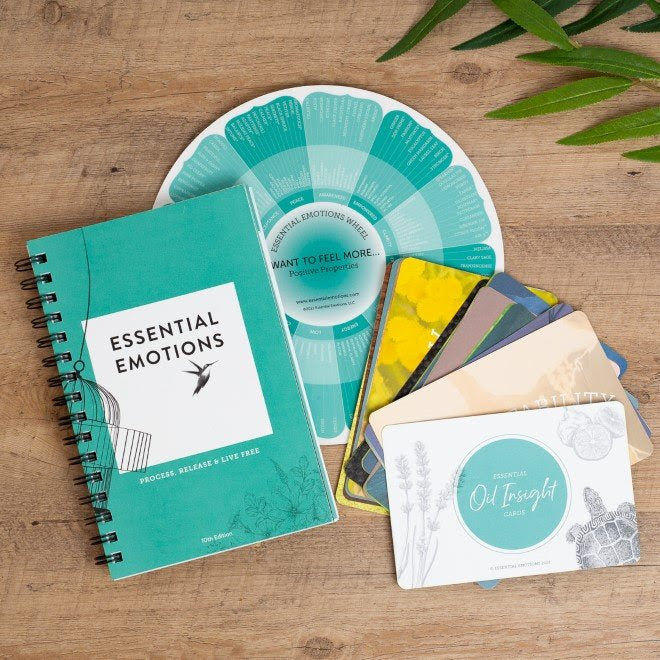 The Essential Emotions book, wheel and insight cards displayed nicely on a wooden surface.
