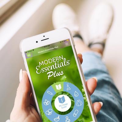 Someone sitting in a window seat with the Modern Essentials Plus app menu pulled up on their phone. 