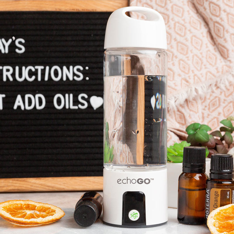 The Echo Go hydrogen water bottle with essential oil bottles and a decorative letter board.