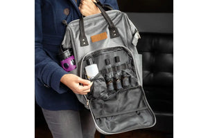 A woman holding up the doTERRA  Branded Backpack with the front pocket open displaying essential oil vials, roller bottles, and a larger carrier oil bottle.