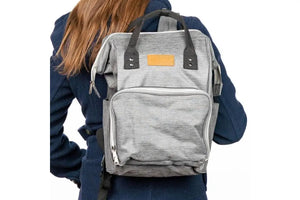 A woman wearing the doTERRA Wellness Advocate Branded Backpack in a graphite, gray color.